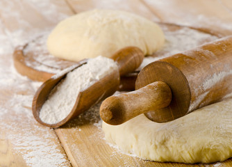 Raw Dough with rolling pin on  wooden background
