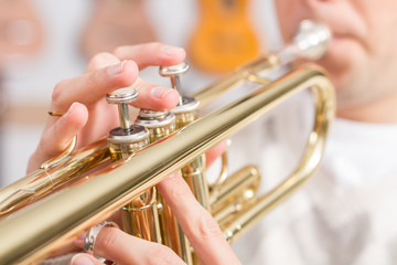 Fototapeta na wymiar Close up of fingers playing a trumpet