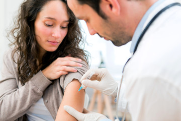 Young attractive woman being vaccinated