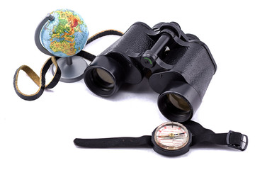 large binoculars, globe and compass on a white background