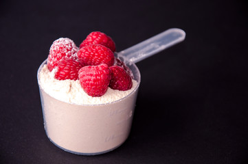 Raspberries in a scoop of protein powder