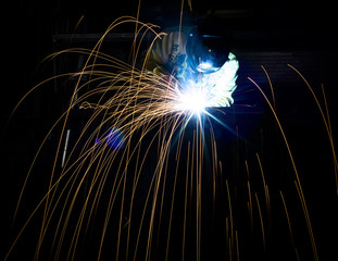 Employee welding steel structures with sparks