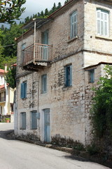 Fototapeta na wymiar Mediterranean house painted white with blue window shutters