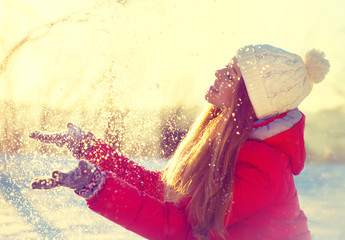 Beauty winter girl blowing snow in frosty winter park