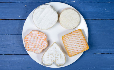 different French cheeses on a table blue wood