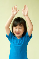 Excited asia little child raising two hand up