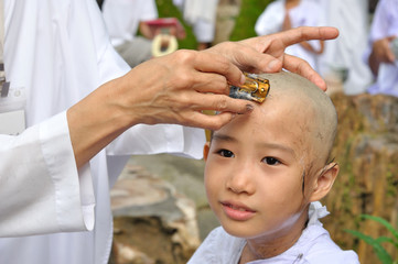 little girl be removed hair to become a nun during a Buddhist o