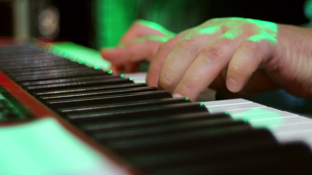 close-up of hands playing the piano