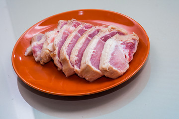 Raw sliced pork in the orange dish - Ingredient