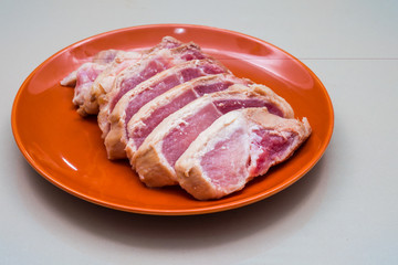 Raw sliced pork in the orange dish - Ingredient