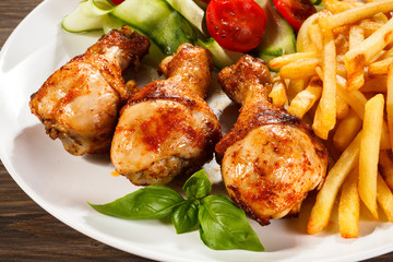 Grilled chicken legs with chips and vegetables
