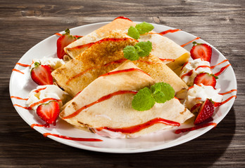 Pancakes with cream and strawberries