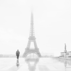 Man and the Eiffel Tower, rain and fog.