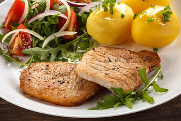 Fried steaks, boiled potatoes and vegetable salad
