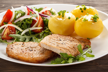 Fried steaks, boiled potatoes and vegetable salad