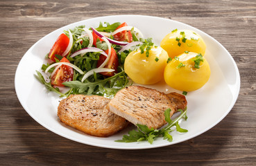 Fried steaks, boiled potatoes and vegetable salad