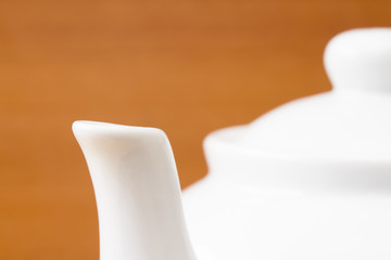 Close up white teapot on wooden table