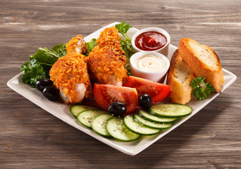 Fried chicken drumsticks and vegetables