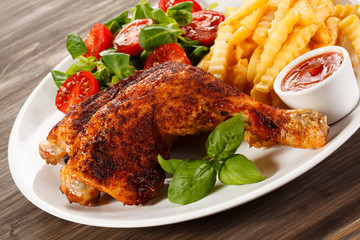 Grilled chicken legs with chips and vegetables