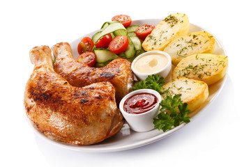 Barbecued chicken legs with baked potatoes and vegetables