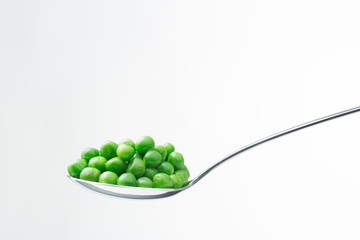 spoon with peas isolated on white background