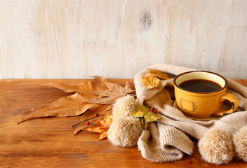 Fototapeta na wymiar Top view of Cup of black coffee with autumn leaves, a warm scarf