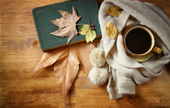 Top view of Cup of black coffee with autumn leaves, a warm scarf