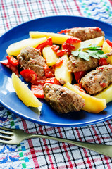 meat cutlets baked with potatoes, tomatoes and red pepper