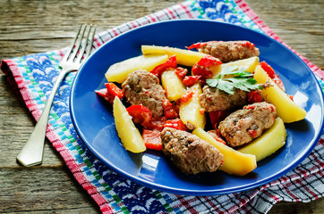 meat cutlets baked with potatoes, tomatoes and red pepper