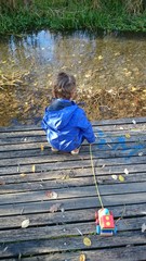 Kind auf Steg mit Spielzeug Eisenbahn