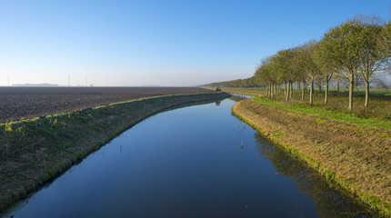 Canal in a rural landscape under a clear sky at fall