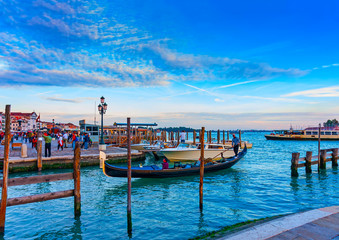 several Gondolas docked at Venice Italy. Sunset time