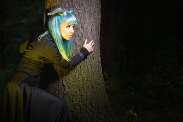 Beautiful woman with color hair and horns holds black bouquet