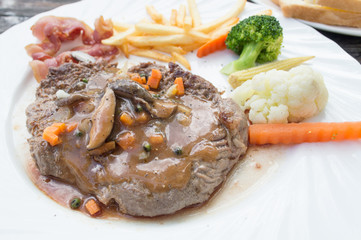 Grilled steaks, French fries and vegetables