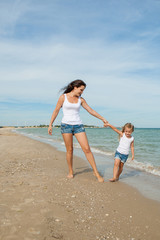 Mother and her daughter  having fun on the beach