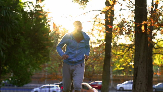Man running in the sunlight, slow motion shot, steadycam shot