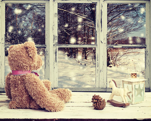 teddy bear and rocking horse looking at snowy night