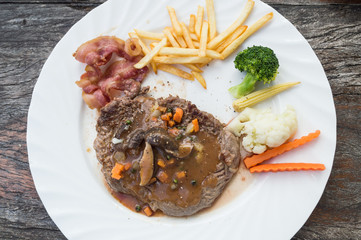 Grilled steaks, French fries and vegetables
