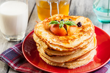 Pancakes with honey, fruit and glass of milk