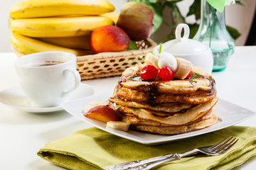 Pancakes with chocolate sauce fruit and coffee