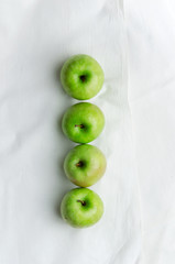 Green apples over white cloth