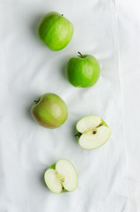 Green apples over white cloth