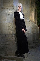 Beautiful woman in Gothic style with long blond hair near church