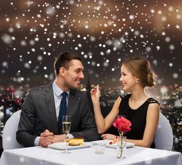 smiling couple eating dessert at restaurant