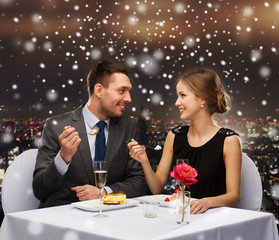 smiling couple eating dessert at restaurant