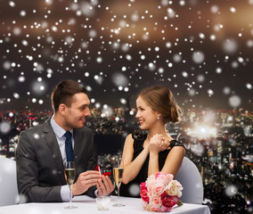 smiling couple with red gift box at restaurant
