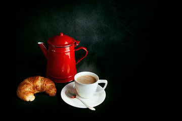 Breakfast still-life with red coffee pot, croissant and cup
