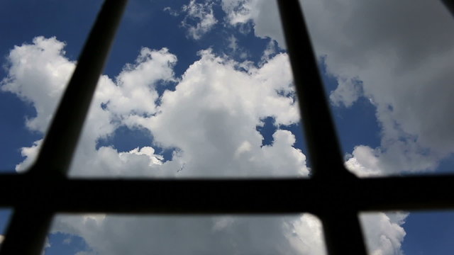 Dolly shot of Prison bars and blue sky