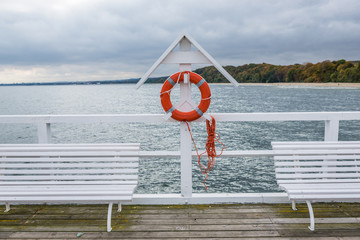 Obraz premium White benches on pier in Orlowo district in Gdynia, Poland