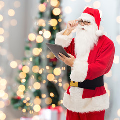 man in costume of santa claus with tablet pc